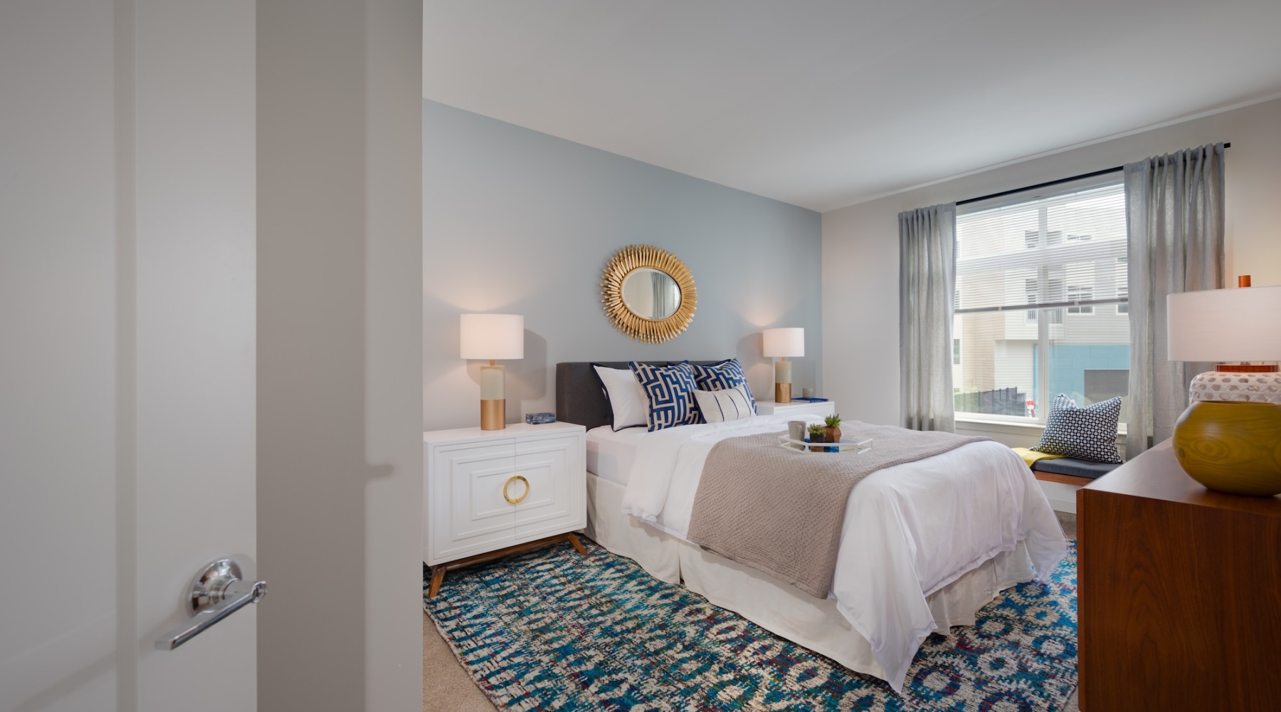 bedroom with a large window and nightstand with lamp