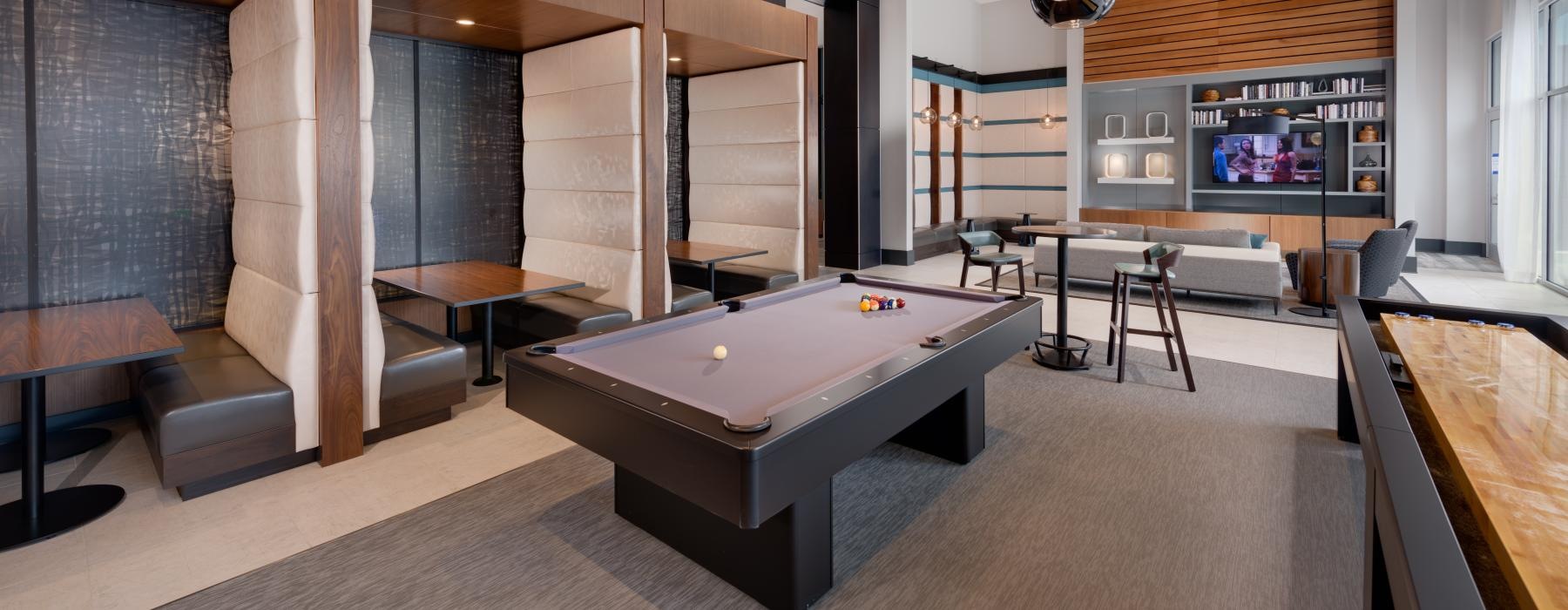 a room with a pool table and chairs